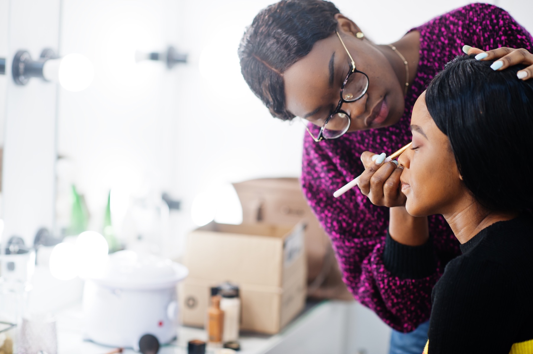 Artist carefully working around a client's eye